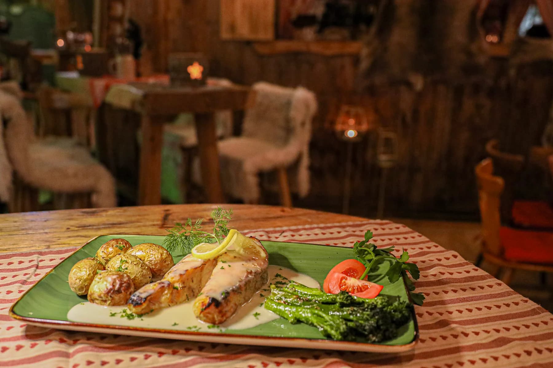 Lachs mit Kartoffeln und Gemüse auf einem gedeckten Tisch in unserer Holzhütte